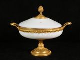 an image of a white and gold covered bowl on a black background