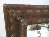 une photo d'un miroir orné de rivets