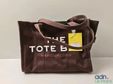 Le sac fourre-tout est marron et comporte une étiquette jaune.
