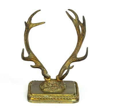 des bois de cerf en laiton posés sur un socle carré, sur fond blanc