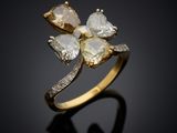 a close up of a gold ring with three white diamonds