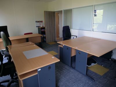deux bureaux et une chaise dans un bureau vide