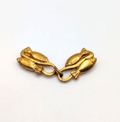 two gold hands clasps on a white surface