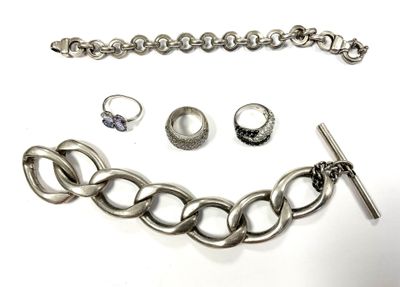 un ensemble composé d'un collier, d'un bracelet et d'une bague, posé sur une surface blanche
