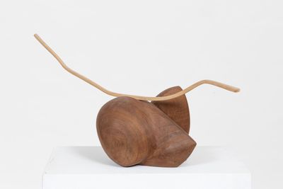 wooden sculpture of a mouse on top of a white pedestal
