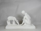 statue of a woman and a child with a dog on a white base