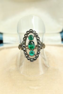 Gros plan sur une bague contenant une pierre verte