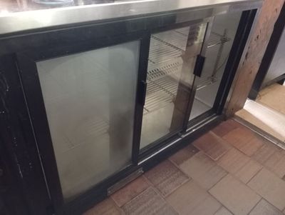 an image of a commercial kitchen with a stainless steel counter top and glass doors