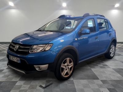 La Dacia bleue est garée dans une pièce au sol carrelé.