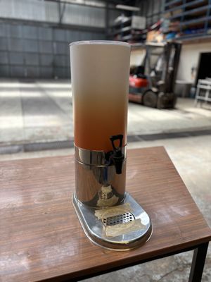 un distributeur de boissons posé sur une table devant un bâtiment