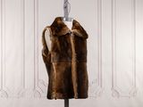 an image of a fur vest on a mannequin stand in front of a white wall