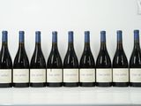 six bouteilles de vin sont alignées sur une table