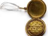a small gold locke with a picture of a man on it
