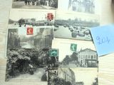 de nombreuses cartes postales anciennes posées sur une table, avec une calculatrice à côté