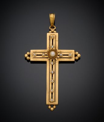 une croix en or avec une perle au centre, sur fond noir
