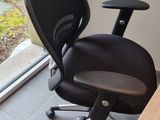 a black office chair sitting in front of a sliding glass door