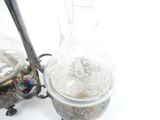 a silver vase and a silver teapot on a table