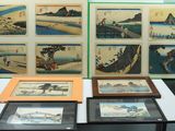 une table sur laquelle sont posées plusieurs œuvres d'art encadrées