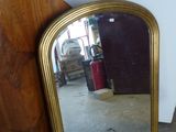 un miroir posé sur le sol à côté d'une chaise