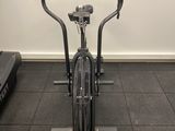 un vélo d'appartement dans une salle de sport équipée de tapis de course et d'un tapis roulant