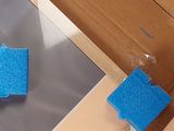 a blue sponge on a piece of plastic next to a cardboard box