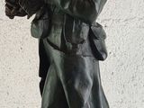 statue of a man holding a knife and a book in his hand