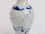 a blue and white vase sitting on a white surface
