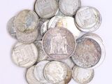 a pile of silver coins on a white surface