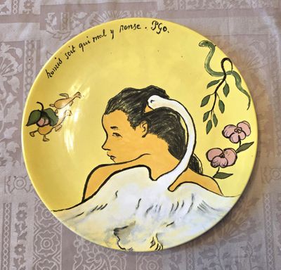 une assiette jaune sur laquelle est représentée une petite fille et un oiseau