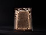 a gold plated picture frame sitting on top of a black surface