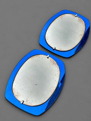 une paire d'assiettes bleues et blanches posées sur une surface grise, sur fond gris