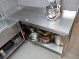stainless steel counter with a mixer and pots on it in a commercial kitchen
