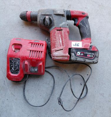 une perceuse filaire et un marteau perforateur filaire posés par terre