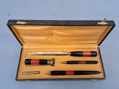 un étui contenant un stylo, un crayon et d'autres objets