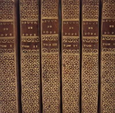 les dos des vieux livres sont alignés sur une étagère