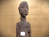 a wooden statue of a person with a tag on it