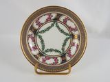 a close up of a plate on a stand on a white surface