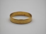a gold wedding ring on a white background