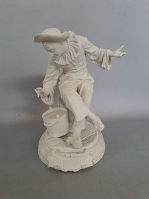 une statue blanche représentant un homme avec un seau posé sur une table