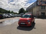 une petite voiture rouge garée devant un immeuble