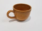 a brown cup that is sitting on a white surface