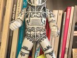 a toy that is sitting on a shelf in front of a bookshelf