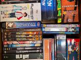 un grand nombre de dvd dans une boîte posée sur le sol