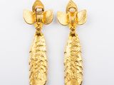 a pair of gold earrings with leaves on them