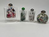 three glass bottles with different designs on them sitting on a white surface