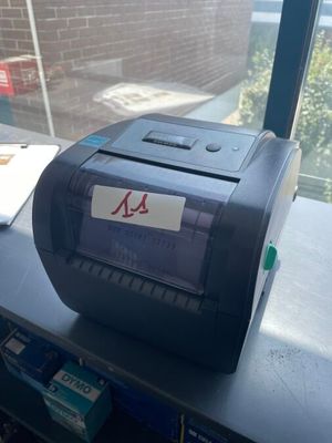 a printer sitting on a desk in front of a window