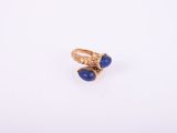 Gros plan sur une bague en or ornée de pierres bleues