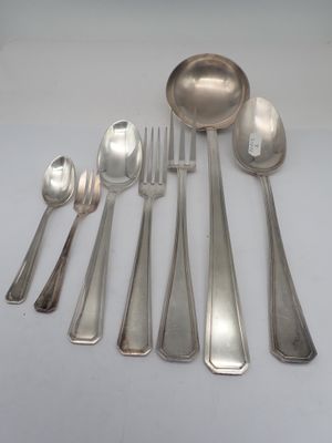 a lot of silver spoons and spoons sitting on a table