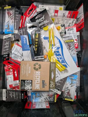 many different types of fishing lures in a bin