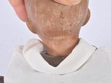 a hand that is holding a clay head of a man